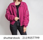 Woman wearing pink bomber jacket and black jeans isolated on white background. Copy space