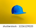 Blank cap in perspective view. Blue snapback on yellow background. Blank baseball snap back cap for your design. Mock up hat cap for you logo, brand identity etc.