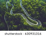 A winding road between tropical forests is visible from the air in North Sumatra, Indonesia.