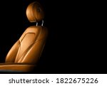 Modern luxury car brown leather interior. Part of orange leather car seat details with white stitching. Interior of prestige car. Comfortable perforated leather seats. Perforated leather. 
