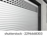 Small photo of Roller shutter gate. Metal roller garage door as background. Automatic electric roll-up garage gate. Garage with white rolling gates.