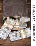 Small photo of Brown paper bag containing that moolah. Bag full of money - vintage photography of brown paper bag with stacks of hundred dollar bills on wooden background