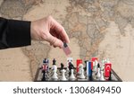 Small photo of Politician's hand moves a chess piece with a flag. Conceptual photo of a political game. retaliatory move USA