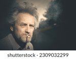 Aged man smoking cigarettes in city park lately on day time