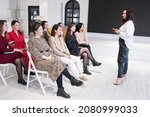 Small photo of Side view of people listening to coach having speech at business training. A group of women attending seminar in conference hall. Lifelong learning concept
