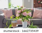 Small photo of Pink peonies and potted plants brighten up the living room for Spring