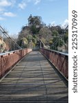 Small photo of Paris, France - 01 15 2023: Park des Buttes Chaumont. View of the Footbridge joining the belvedere island, the Temple of the Sibyl
