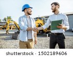 Small photo of Builder choosing heavy machinery for construction with a sales consultant shaking hands on the open ground of a shop with special vehicles