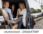 Business people sitting in minivan taxi, view through an open door. Concept of business trips and transportation