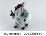 Small photo of Lead-colored donkey with its saddlebag. Crochet stuffed animal