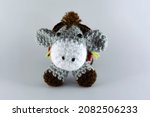Small photo of Small-eared donkey with its brown saddlebag. Crochet stuffed animal