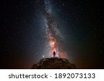 Man on top of a mountain observing the universe