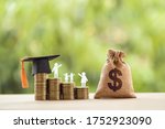 Black graduation cap, hat, student and kid, rows of rising coins, white clock on a table, natural green background. Public school funding, education funding, financial concept