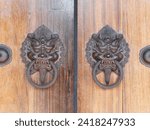 Small photo of Old Chinese style door handle on wooden door, antique oriental door knocker. Traditional Chinese doors with brass lion head door knockers
