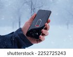 Small photo of Low battery on smartphone in man hand. Winter, cold time. Concept of faster battery discharge at low temperatures
