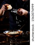 Small photo of Man cooking with hard italian cheese, grated parmesan or grana padano cheese, hand with cheese grater
