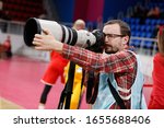 Small photo of FEBRUARY 23, 2020 - ZAPORIZHIA, UKRAINE: Reporter with photo camera. Journalist shooting Eurobasket 2021 Qualifers match Ukraine-Hungary using Canon telephoto lens EF 400mm 2.8