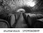 Small photo of Wine barrels in a wine cellar. Small production. Underground tunnel. Storage of finished products. deep sharpness on a wide angle lens. Black and white