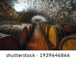 Wine barrels in a wine cellar. Small production. Underground tunnel. Storage of finished products. deep sharpness on a wide angle lens