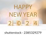 Small photo of Happy New Year 2024 on wood cube block and blur abstract bokeh light background, Happy new year 2024 greeting card, banner