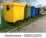 Small photo of Black, blue, yellow, green garbage recycling bins on street in city. Separate waste, recycling environment concept. Segregate waste, sorting garbage. Colored trash cans with paper, glass, plastic