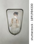 Small photo of woman in the mirror takes off her mask, concept of introspection and identity crisis