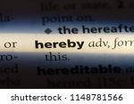 Small photo of hereby word in a dictionary. hereby concept.