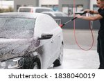Cleaning car using active foam. Man washing his car on self car-washing