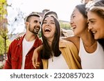 Small photo of Diverse group of young friends having fun together outdoors in summer. Millennial student people laughing walking in city street enjoying day off. Youth community and friendship concept.