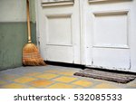Broom At The White Wooden Door