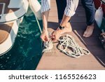 Small photo of Man s hand with boat rope. Yachtsman moors his motor boat at jetty. Close up hands and bow of the boat.