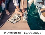 Small photo of Male hands with boat rope. yachtsman tying sea knot while mooring the Yacht. Close up hands