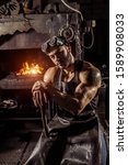 Small photo of confident good-lloking artisan in leather brown apron or uniform, young caucasian forger with beard wearing gloves