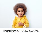 Small photo of cheerful fluffy african american girl looking happy holding magic wand in hands, laughing, isolated on white studio background. portrait. people diversity, african ethnicity, childhood concept