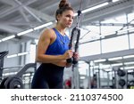 Small photo of caucasian slim woman in sportive blue top and leggins training with triceps kickback in modern gym. fit athlete lady concentrated on workout, alone. cross fit, healthy lifestyle, fitness, sport