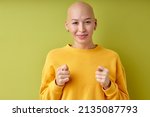Small photo of hairless woman showing fig sign isolated on green background, you don't get it anyway. portrait of Stylish woman with nice face shows fig. Concept protest and objection. I don't give up