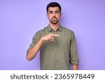 Small photo of serious handsome man showing letter Hh with fingers .the Alphabet in American Sign Language (ASL). isolated blue background closeup portrait