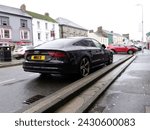 Small photo of 20th February 2024- A sporty Audi A7 S Line Black Edition Tdi Quattro, five door hatchback car, parked on a road in the town center at Carmarthen, Carmarthenshire, Wales, UK.