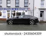 Small photo of 20th February 2024- A sporty Audi A7 S Line Black Edition Tdi Quattro, five door hatchback car, parked on a street in the town center at Carmarthen, Carmarthenshire, Wales, UK.