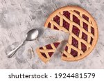 Whole pie called 'Linzer Torte', a traditional Austrian shortcake pastry topped with fruit preserves and sliced nuts with lattice design with slice cut out