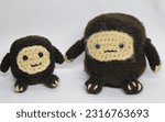 Small photo of Hand Made Amigurumi Sasquatch and Child Bigfoot with Baby Isolated Against White Background Crocheted Yarn Art Stuffed Toy