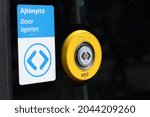 Yellow door opener button outside of a tram. English and Hungarian text next to the button. 'Nyit' text on the button means 'Open'