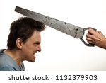 Small photo of Old hacksaw in female hands over his head an angry, disheveled and frightened man. The concept of female grumbling and negative reaction of a man. Family dissension. The wife is peeling her husband