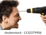 Small photo of A drill in female hands is aimed at the forehead of an angry, disheveled man. The concept of female grumbling and negative reaction of a man. Family dissension. Wife drills her brain to her husband