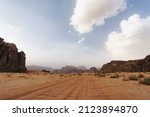 Wadi Rum desert, Jordan, The Valley of the Moon. Orange sand, haze, clouds. Designation as a UNESCO World Heritage Site. National park outdoors landscape. Offroad adventures travel background.