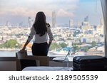 Woman relaxing at apartment or hotel after business meeting. Business trip. Booking hotel during your vacation. Businesswoman in luxury room, looking spectacular metropolitan city through hotel window