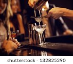 Barman pouring wine from shaker and serving it