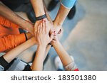 Multiethnic group of young people putting their hands on top of each other. Close up image of young students making a stack of hands.