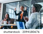 Small photo of Employee of the month. Cheerful young businesswoman smiling while being applauded by her colleagues in a modern office. Happy young businesswoman receiving praise from her team during a meeting.