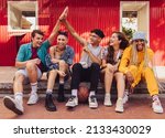 Small photo of Here's to friendship. Group of multiethnic young people enjoying hanging out together outdoors in the city. Cheerful generation z friends having fun and making happy memories.